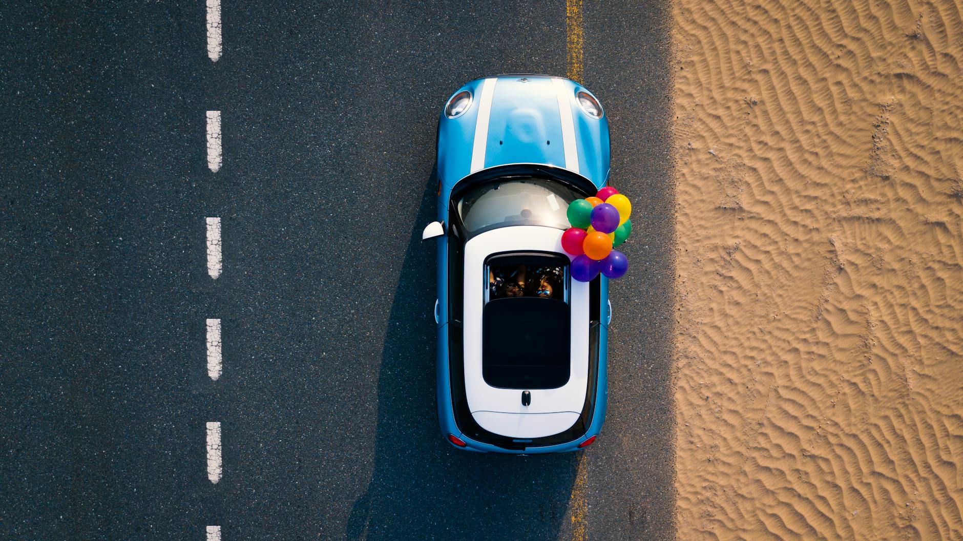 aerial photography of blue car on road